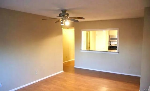 spare room with ceiling fan and light wood-type flooring