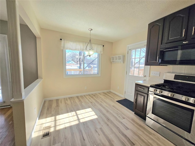 kitchen featuring light hardwood / wood-style flooring, stainless steel range with gas stovetop, a textured ceiling, and decorative light fixtures