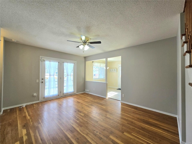 empty room featuring ceiling fan, dark hardwood / wood-style flooring, and a textured ceiling