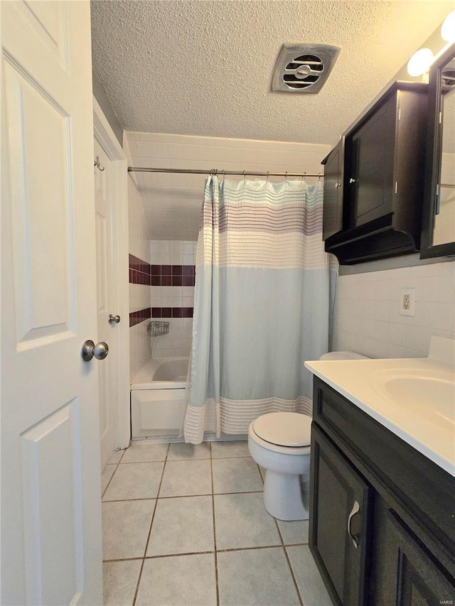 full bathroom with tile patterned flooring, vanity, a textured ceiling, and shower / bath combo with shower curtain