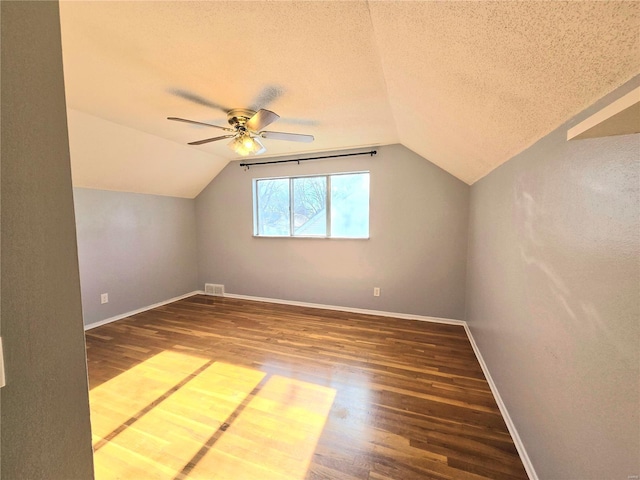 additional living space with vaulted ceiling, ceiling fan, hardwood / wood-style floors, and a textured ceiling