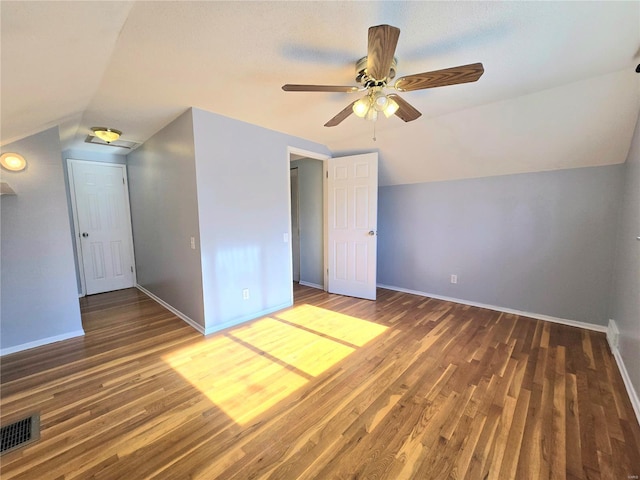 additional living space featuring dark wood-type flooring, ceiling fan, and vaulted ceiling