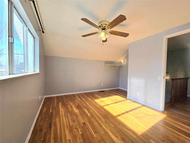 additional living space with vaulted ceiling, wood-type flooring, and ceiling fan