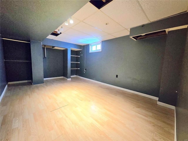 basement featuring hardwood / wood-style floors and a paneled ceiling