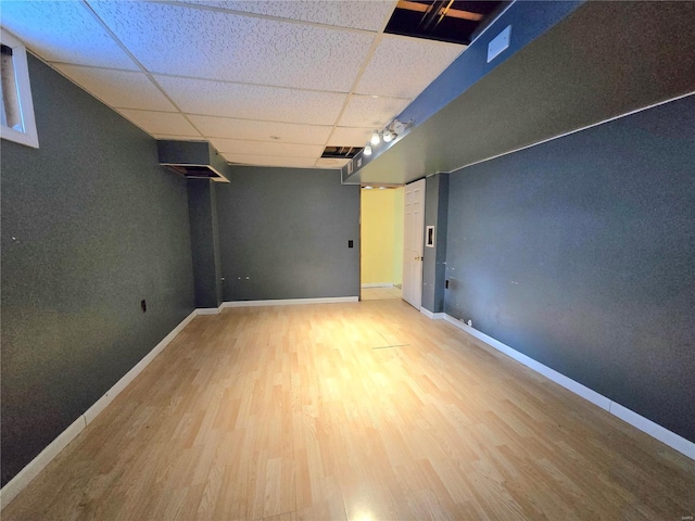 basement featuring a paneled ceiling, track lighting, and hardwood / wood-style floors