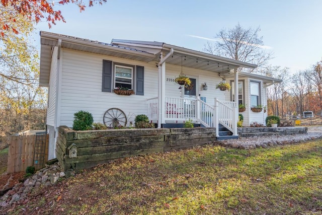 single story home with covered porch and a front yard