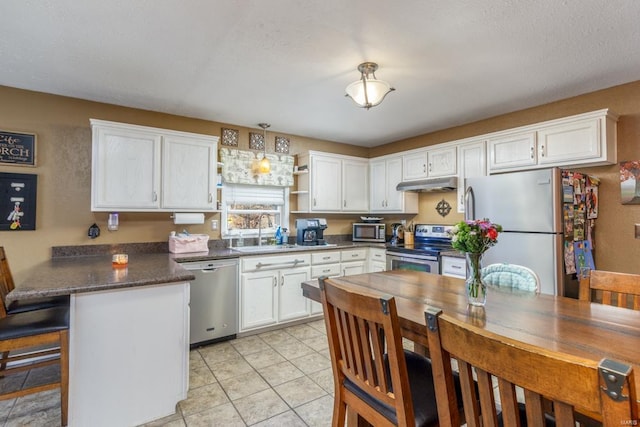 kitchen with white cabinetry, sink, a textured ceiling, light tile patterned floors, and appliances with stainless steel finishes