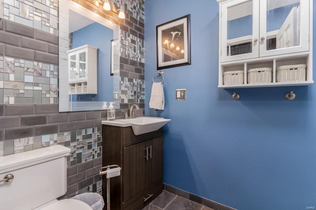 bathroom featuring vanity, tile walls, and toilet