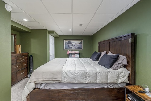 bedroom with a drop ceiling and carpet floors