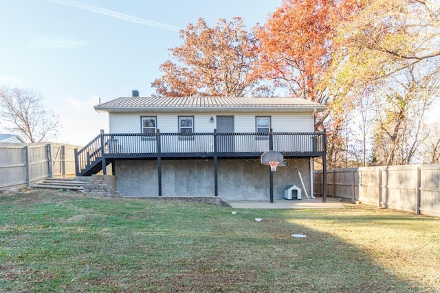 rear view of house featuring a wooden deck, a yard, and a patio