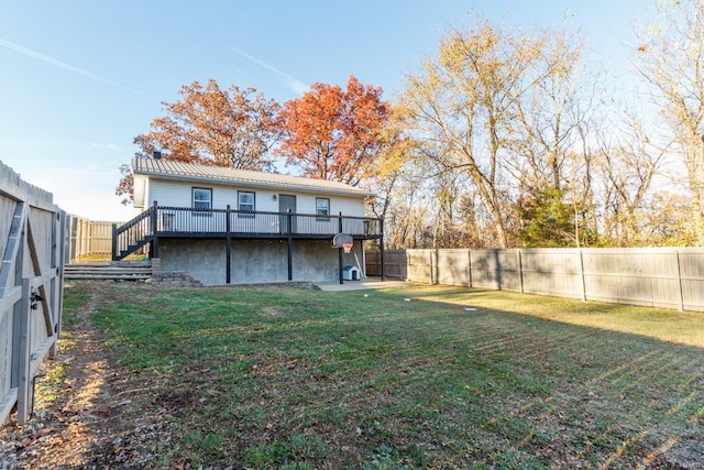 rear view of property with a yard and a wooden deck