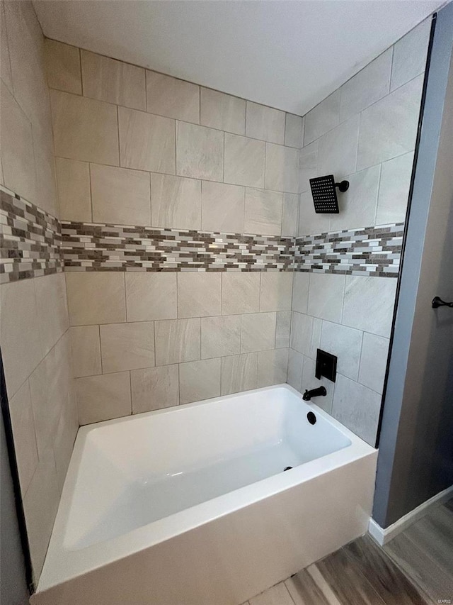 bathroom featuring hardwood / wood-style floors and tiled shower / bath