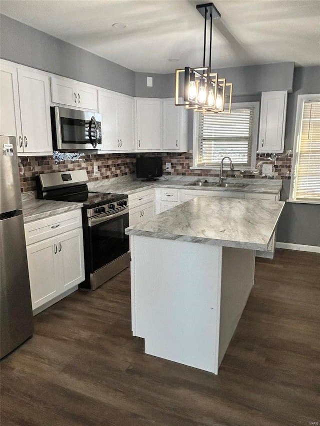 kitchen featuring pendant lighting, a center island, white cabinetry, and appliances with stainless steel finishes