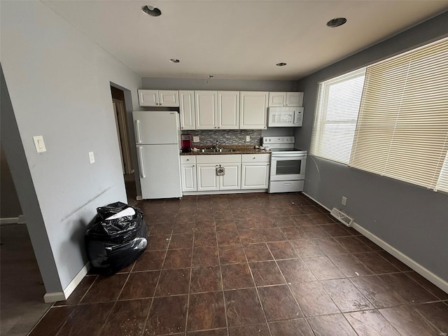 kitchen featuring tasteful backsplash, white cabinetry, sink, and white appliances