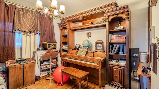 miscellaneous room with light wood-type flooring and a notable chandelier