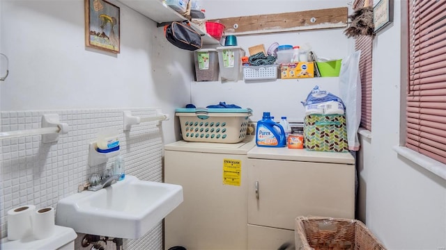 clothes washing area with washer / dryer, tile walls, and sink