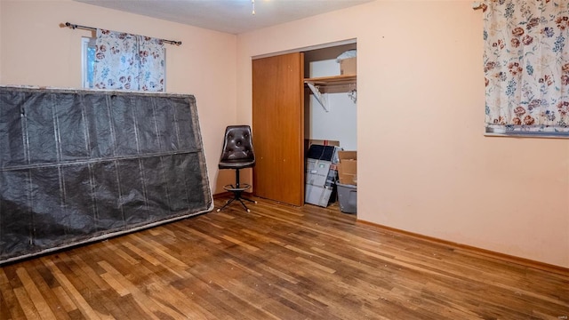 unfurnished bedroom with hardwood / wood-style floors and a closet