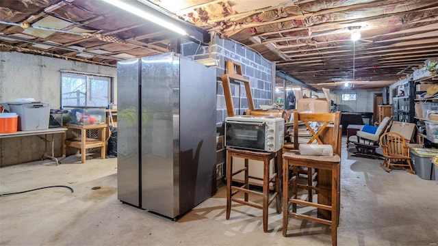 basement featuring stainless steel refrigerator