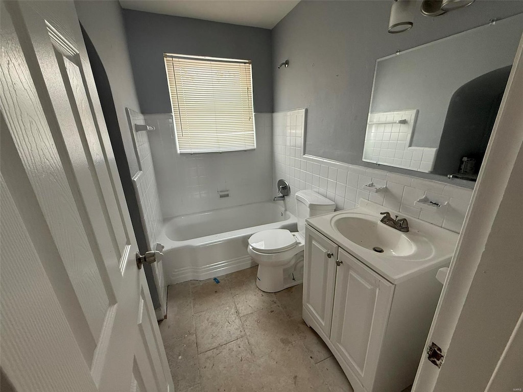 full bathroom with vanity, shower / washtub combination, toilet, and tile walls