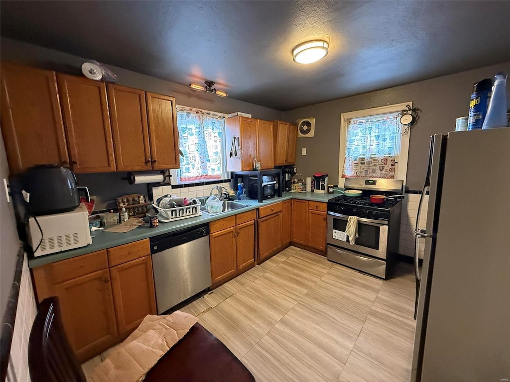 kitchen featuring a textured ceiling, stainless steel appliances, and sink