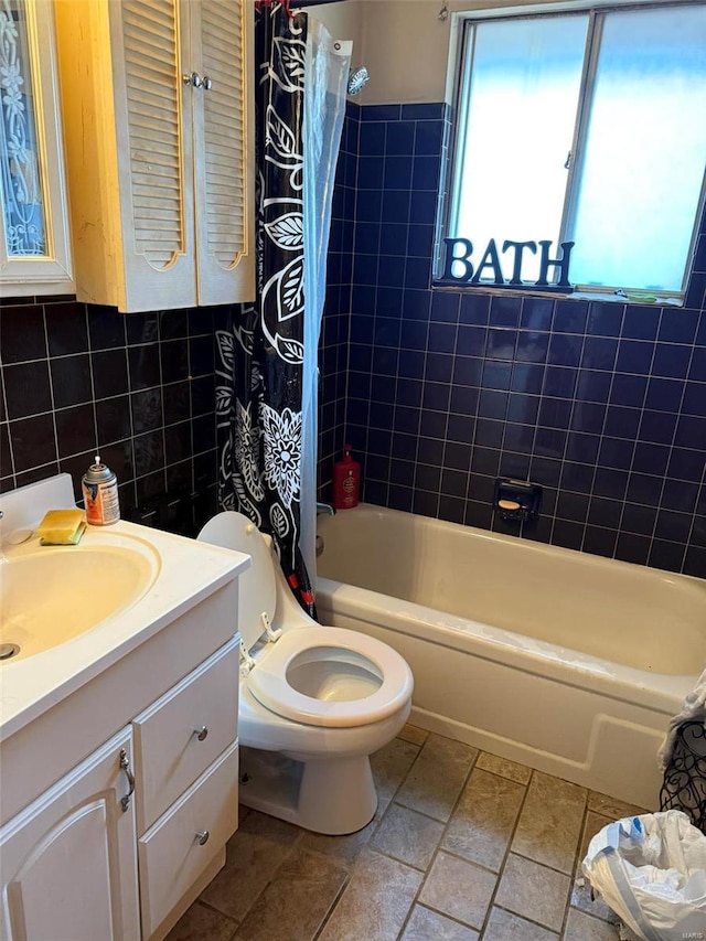 full bathroom with vanity, backsplash, toilet, shower / bathtub combination with curtain, and tile walls