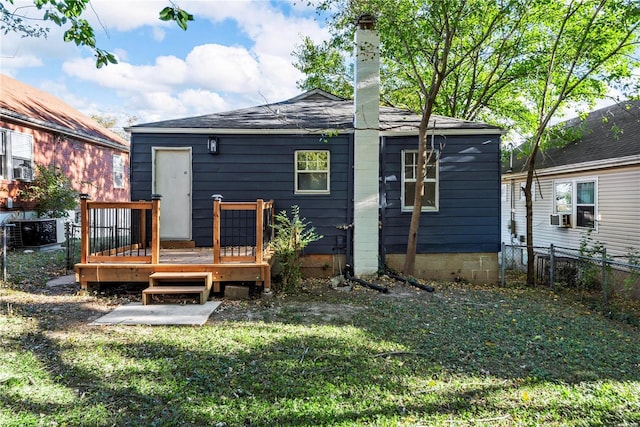 back of property with a wooden deck and a yard