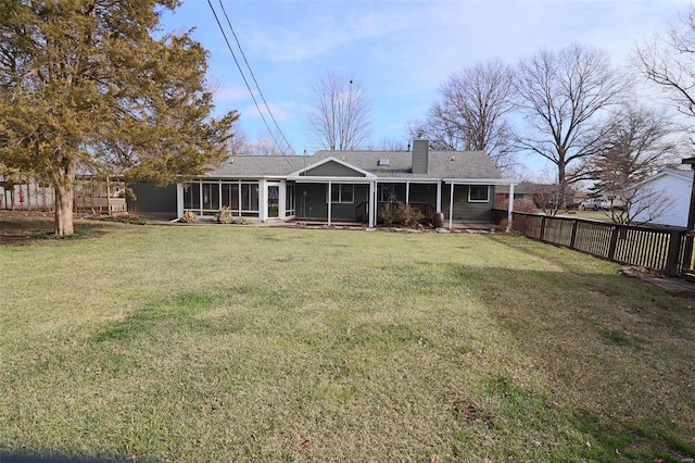 back of property featuring a lawn and a sunroom