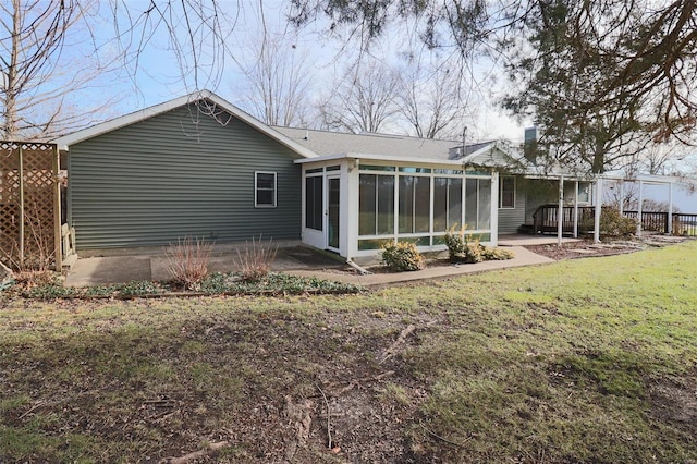 back of house featuring a sunroom, a patio area, and a yard