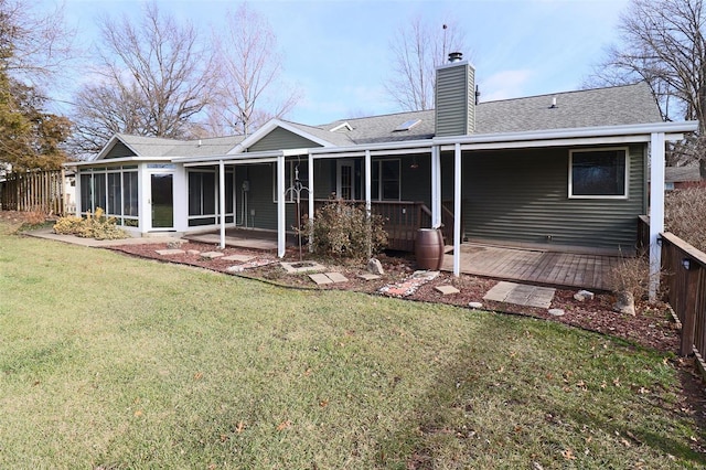 rear view of property with a lawn and a sunroom