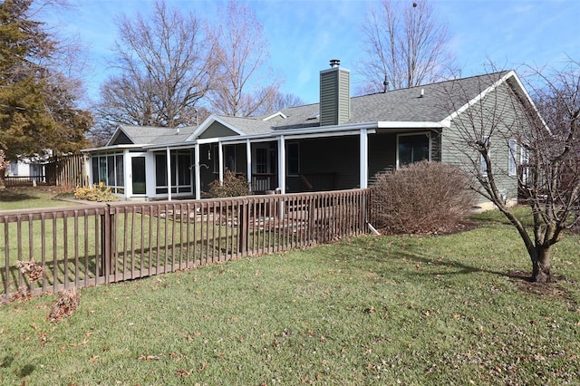 back of property with a sunroom and a yard