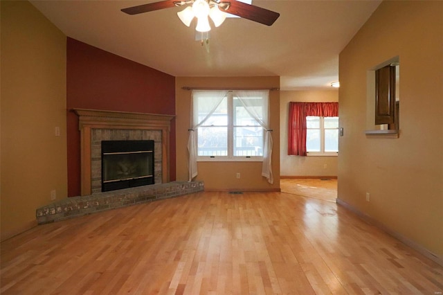 unfurnished living room with a fireplace, light hardwood / wood-style floors, and ceiling fan