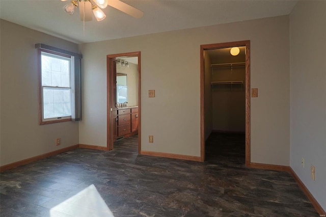 unfurnished bedroom featuring ceiling fan, a spacious closet, and a closet