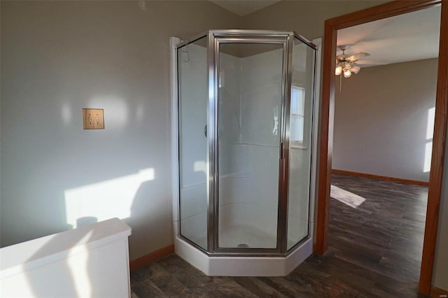 bathroom featuring hardwood / wood-style floors, ceiling fan, and a shower with door