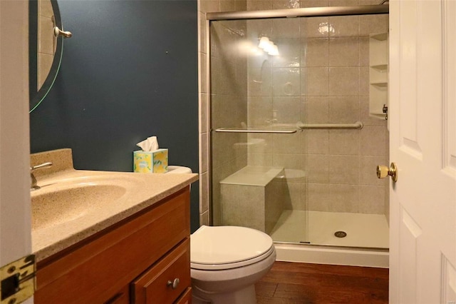 bathroom featuring walk in shower, toilet, vanity, and hardwood / wood-style flooring