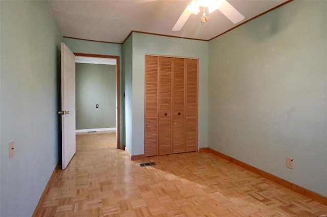 unfurnished bedroom with light parquet flooring, a closet, ceiling fan, and crown molding