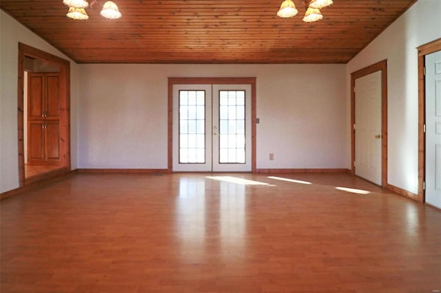 spare room featuring hardwood / wood-style floors, a notable chandelier, wooden ceiling, and vaulted ceiling