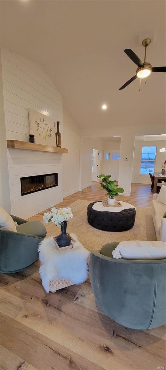 living room featuring vaulted ceiling, hardwood / wood-style floors, and ceiling fan