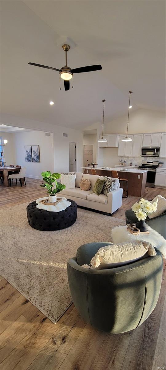 living room with ceiling fan and light hardwood / wood-style flooring