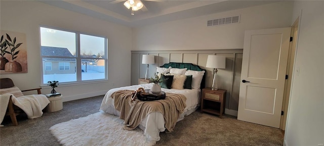 bedroom with carpet, ceiling fan, and a tray ceiling