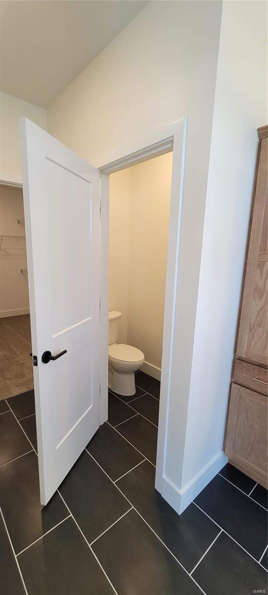 bathroom featuring toilet and tile patterned flooring