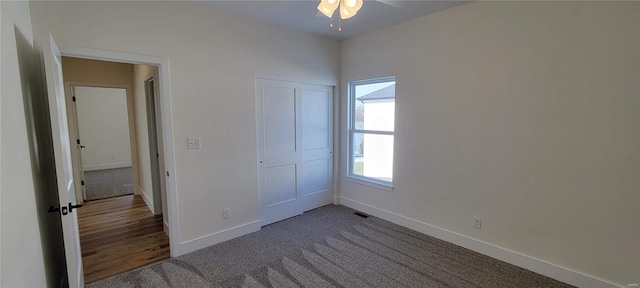 unfurnished bedroom with carpet flooring, ceiling fan, and a closet