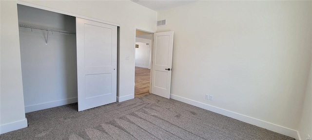 unfurnished bedroom featuring carpet floors and a closet