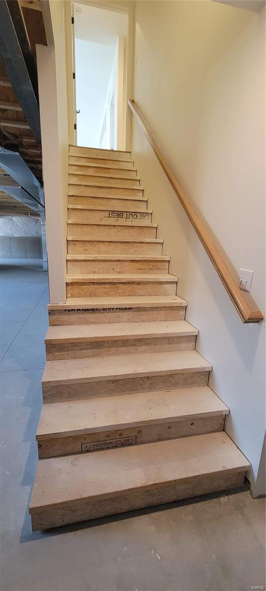 staircase featuring concrete floors