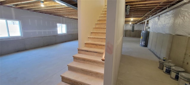 basement featuring water heater and a healthy amount of sunlight