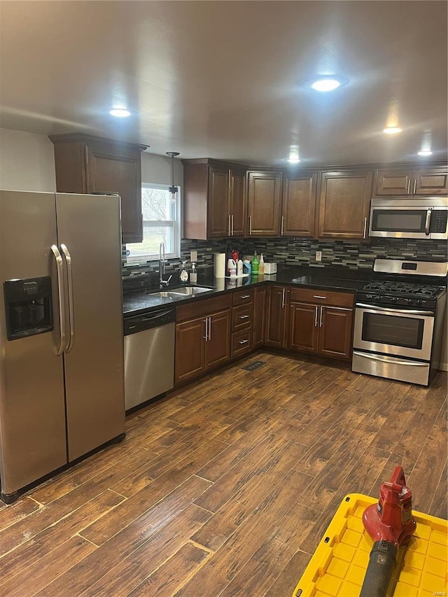 kitchen featuring dark brown cabinetry, sink, appliances with stainless steel finishes, and dark wood-type flooring