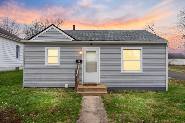 bungalow-style home with a lawn