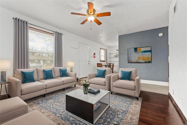 living room featuring ceiling fan and dark wood-type flooring