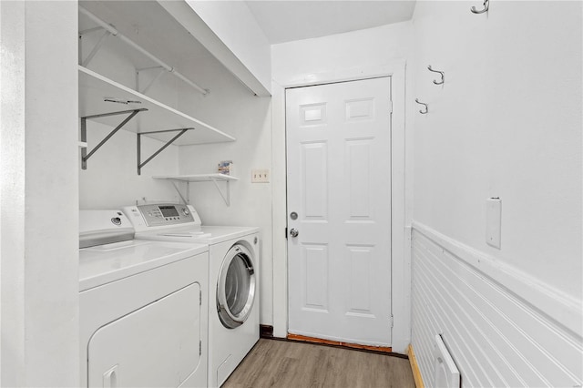 washroom with washing machine and dryer and light hardwood / wood-style flooring