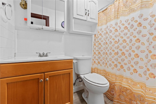 bathroom with vanity, toilet, and tasteful backsplash