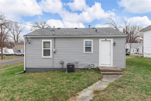 rear view of house with a yard and central AC